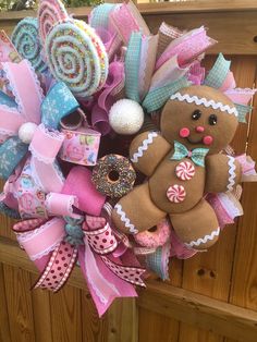 a wreath with a teddy bear, candy and lollipops