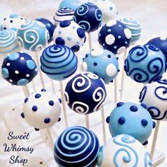 blue and white cake pops with swirly designs on them are ready to be eaten