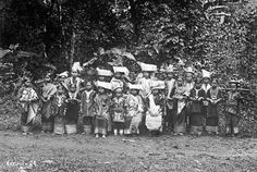 a group of people standing next to each other in front of trees and shrubbery