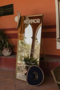 a mirror sitting on top of a tiled floor next to a potted plant in front of it