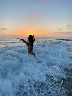 a woman standing on top of a wave in the ocean