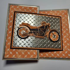 an orange and silver card with a motorcycle on it