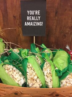 a basket filled with lots of popcorn next to a sign that says you're really amazing