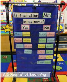 a blue bulletin board sitting on top of a classroom floor with words written in different languages