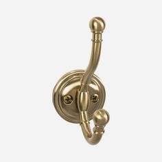 an old fashioned brass hook on a white wall