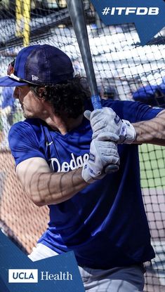 a man holding a baseball bat in his hands and wearing a blue shirt with the word dodgers on it