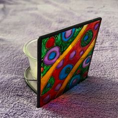 a colorful glass object sitting on top of a purple towel next to a white bowl