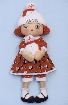 a doll with an adorable outfit holding a snowman