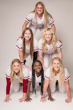 a group of women in baseball uniforms posing for a photo