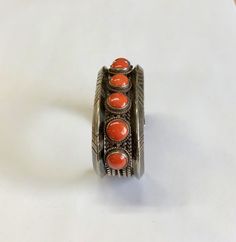 "SALE Vintage, Collectible Heavy, 90 Gram, Sterling Silver Cuff With 7 Natural, Round, Domed, Precious Red Coral And Twisted Wire Accents Was $895.00 now $595.00! A substantial sterling silver cuff with a total weight of 90 grams with natural red coral. 5 9/16\" long plus the gap of 1 5/16\" equals a total of approximately 6 7/8\" in length and 1\" in width. The base of the cuff is made up of a series of wires soldered together. There is a 5x5mm triangular wire on either side with a series of st Handmade Red Cuff Bracelet For Formal Occasions, Formal Handmade Red Cuff Bracelet, Formal Red Handmade Cuff Bracelet, Deep River, Twisted Wire, Sterling Silver Cuff, Red Coral, Silver Cuff, Natural Red