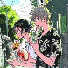 two people standing next to each other eating food and drinking sodas in their hands