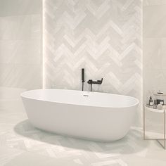 a white bath tub sitting on top of a tiled floor