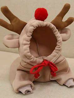 a stuffed animal with a red hat on it's head sitting on a white surface