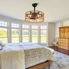 a bed room with a neatly made bed and a large window