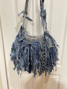 a denim purse hanging on a door handle