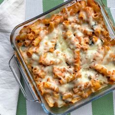 a casserole dish filled with pasta and cheese on a green and white checkered table cloth