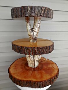 three tiered tree slice cake stand with white frosting and wood slices on top