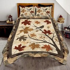 a bed covered in a quilt with leaves on it and a bird sitting on the tree