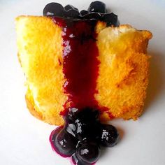 a piece of cake with blueberry sauce on it