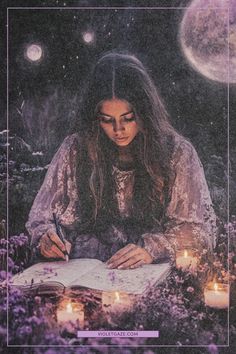 a woman sitting in the middle of a field writing on a paper with candles around her