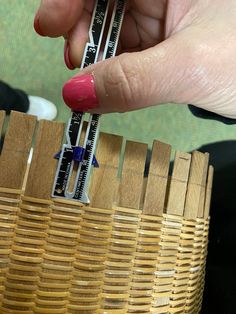 a person is measuring the height of a basket with a meter in their hand,