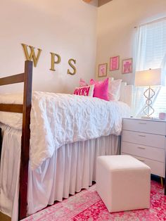 a bedroom with pink and white decor on the walls