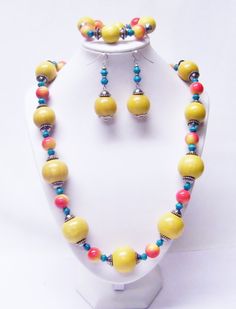 "Large Round Yellow Wood w/Red/Yellow Acrylic Bead Necklace/Bracelet/Earrings Set  This necklace set is made with large round yellow wood beads, 12mm round red and white acrylic beads, 6/7mm turquoise wood beads and silver plated spacer beads strung on flexible beading wire. It is 26\" in length and it fastens with silver plated lobster clasp. It comes with bracelet and earrings that hang from silver plated fish hook ear wires. Necklace Length: 26\" Earrings Length: 2 ½\" (including ear wire)  B Yellow Wood, Beading Wire, Bead Stringing, Wire Bracelet, White Acrylic, Acrylic Beads, Fish Hook, Ear Wire, Necklace Length