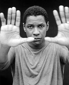 a man with his hands in front of him, making the vulcan sign and looking at the camera