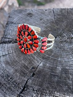 Elevate your jewelry game with Loretta Delgarito's Signature Cluster Cuff. Handmade by Native American artist, this .925 Silver cuff features a stunning cluster design using vibrant red coral. A true statement piece, this cuff is sure to make a bold and unique addition to any outfit. Red Sterling Silver Bangle Cuff Bracelet, Handmade Red Sterling Silver Cuff Bracelet, Red Southwestern Cuff Bracelet As Gift, Red Southwestern Cuff Bracelet Gift, Red Gemstone Cuff Bracelet, Red Gemstone Bangle Cuff Bracelet, Unique Red Bangle Jewelry, Cluster Design, Native American Artists