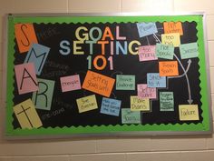 a bulletin board with sticky notes on it that says goal setting 101 and has words written all over it