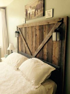 a bed with white linens and wooden headboard made out of old barn doors