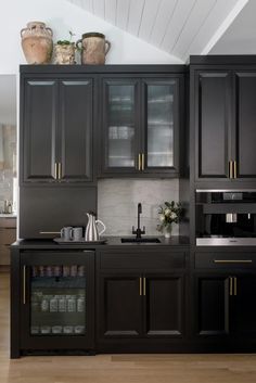 a kitchen with black cabinets and gold trim on the doors, counter tops and drawers