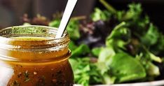 a glass jar filled with food sitting on top of a table next to a salad