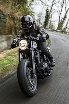 a man riding on the back of a motorcycle down a curvy road