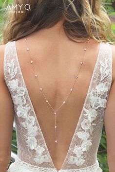 the back of a woman's wedding dress with pearls on it