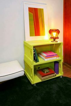 a yellow shelf with books on it next to a white pillow and lamp in the corner