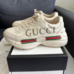 Low-Top Buffed Calfskin Sneakers In Off-White. Round Toe. Tonal Lace-Up Closure. Logo Flag In White At Padded Tongue. Padded Collar. Buffed Calfskin Lining. Multicolor Logo Printed At Outer Side. Tonal Foam Rubber Midsole. Tonal Treaded Rubber Outsole. Gucci Rhyton, Mens Tennis Shoes, Comfortable Walking Shoes, Gucci Tote Bag, Shoes Gucci, Gucci Sneakers, Gucci Logo, Miu Miu Shoes, Gucci Shoes