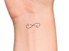 a small wrist tattoo with an infinite symbol on it