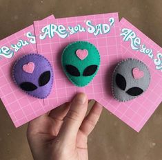 there are three alien brooches with hearts on them