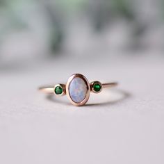 Cabochon genuine opal with two Tsavorite garnet accents. Customizable ring This pearly white opal symbolize a mother with two child. Customizable birthstone available. Solid 14k gold with genuine gemstones. Yellow gold and rose gold available. 14k fully hallmarked. Approx 1.6mm band width with 4x6mm opal, 1.5mm green garnet. LEAD TIME: Made to order will take 10-14 days. All of our jewelry will arrive in custom packaging ready for gift giving. FOLLOW US ON: Instagram: @roseandchoc Facebook: /Ros Antique Gold Opal Ring, Heirloom Green Opal Ring As Gift, Fine Jewelry Opal Ring For May Birthstone, Opal Aquamarine Ring, Fine Jewelry Green Opal Birthstone Ring, Fine Jewelry Green Opal Ring, Oval Cabochon Opal Ring For Anniversary, Opal Birthstone Ring With Oval Cabochon For Anniversary, Heirloom Green Opal Ring Gift