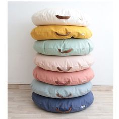 a stack of pillows sitting on top of each other in front of a white wall