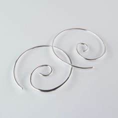 Each hand formed sterling silver spiral earring has been lightly hammered for strength and polished to shine.  These simple swirls are quite versatile and great for everyday wear! This is one of my most popular styles of earring; as each pair is hand formed, they may vary slightly. Earring Length/Diameter ▾ approx. 7/8 inches (2.2 cm) Wire Gauge ▾ 20 gauge (standard piercing), sterling silver As with all of my earrings, the end that passes through the ear has been filed smooth. I also include a pair of rubber stoppers for each pair of earrings, and a small sterling silver polishing cloth. This style is also available in niobium wire: https://www.etsy.com/listing/905007656/niobium-spiral-earrings-small?ref=shop_home_active_1 Handmade Minimalist Spiral Hoop Earrings, Silver Spiral Hoop Earrings, Silver Spiral Handmade Hoop Earrings, Unique Spiral Nickel-free Hoop Earrings, Nickel-free Silver Spiral Hoop Earrings, Hoop Earrings Handmade, Wire Gauge, Popular Styles, Spiral Earrings