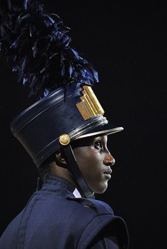 a woman wearing a hat with feathers on it