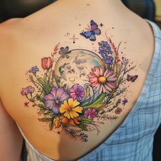 a woman's back with flowers and butterflies on her left shoulder, the moon in the background