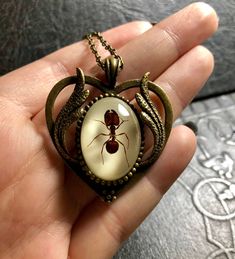 "The perfect piece to wear on a picnic! Its a big headed red ant, centered and encased in clear resin with white backing, mounted on a bronze colored, flower ring setting, with a matching 18\" chain. The cameo is such high relief, it looks like the bug is floating! The Cabochon alone is 18x25mm. Talk about a conversation starter! This is the EXACT piece you will be getting. No \"random specimens\" here!Since each piece is made one at a time, there may be imperfections, so feel free to look him o Red Resin Novelty Jewelry, Novelty Red Resin Jewelry, Red Heart-shaped Novelty Jewelry, White Heart-shaped Resin Jewelry, Vintage Red Resin Jewelry, Bug Necklace, Red Ant, The Bug, Big Head