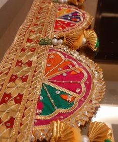 an elaborately decorated piece of cloth with tassels and beads on the edge