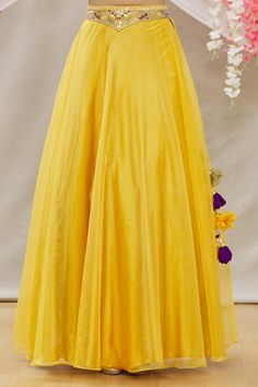 Yellow organza lehenga with embroidered waistband.  Comes with embroidered blouse and green soft net dupatta.
Component: 3
Pattern: Embroidered
Type Of Work: Mirror work
Neckline: V Neck
Sleeve Type: Sleeveless
Fabric: Blouse:Satin; Lehenga:Organza; Dupatta:Soft Net
Color: Yellow
Other Details: 
Side tassel tie-up lehenga
Occasion: Mehendi and Haldi - Aza Fashions Yellow Organza Lehenga, Yellow Mirror, Satin Lehenga, Blouse Satin, Mirror Work Lehenga, Organza Lehenga, Work Lehenga, Embroidered Lehenga, Green Soft