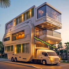 a large white truck parked in front of a tall building with balconies on top