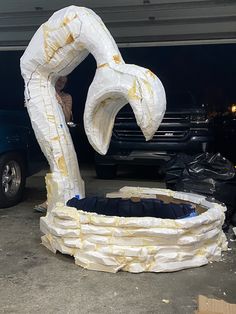 an inflatable object is sitting on the ground next to a parked car and another vehicle