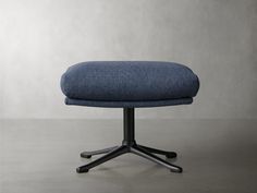 an upholstered blue chair with black metal legs and casteors on a gray background